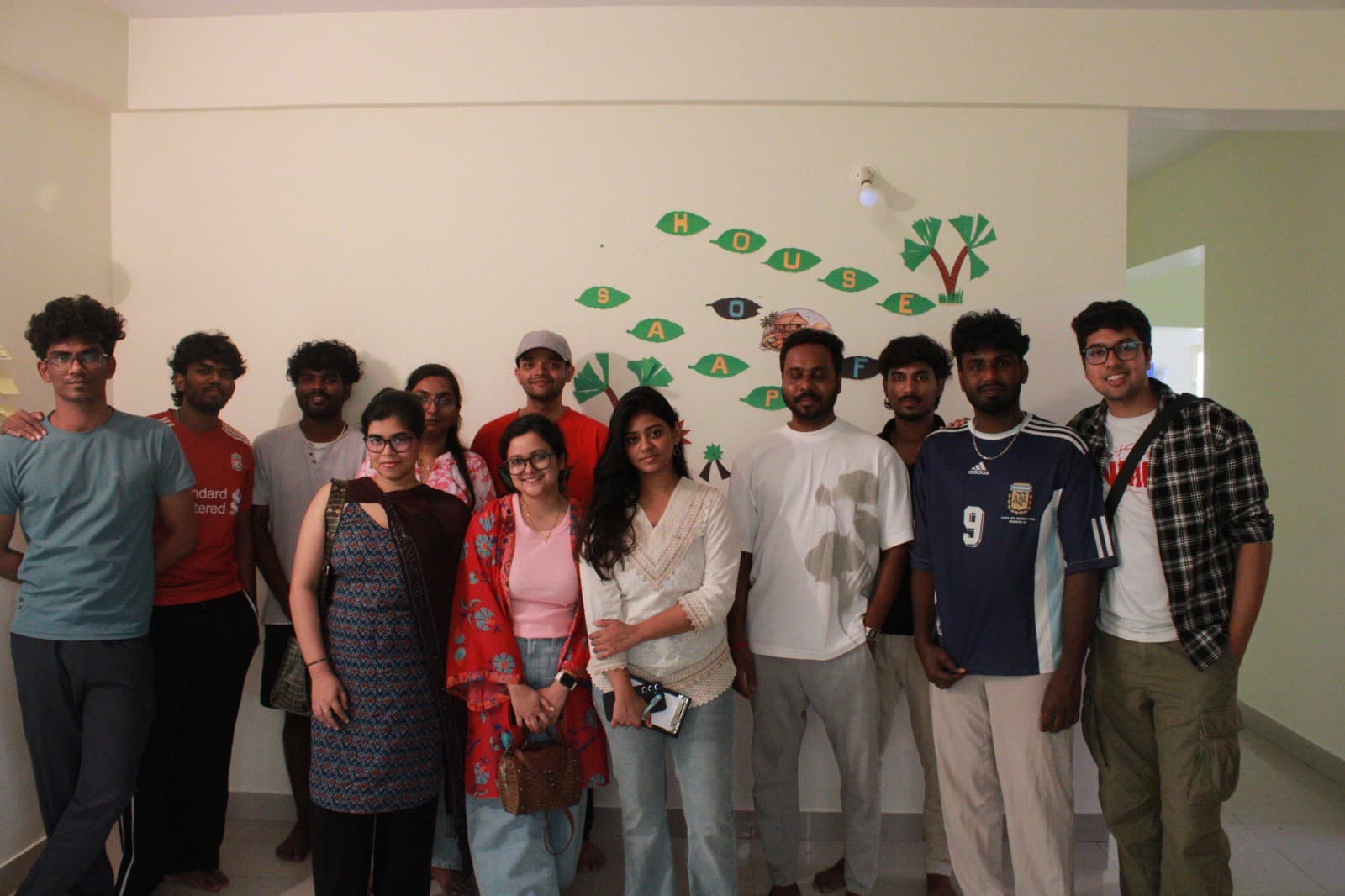 Guests posing in front of the House of Saapadu wall decor